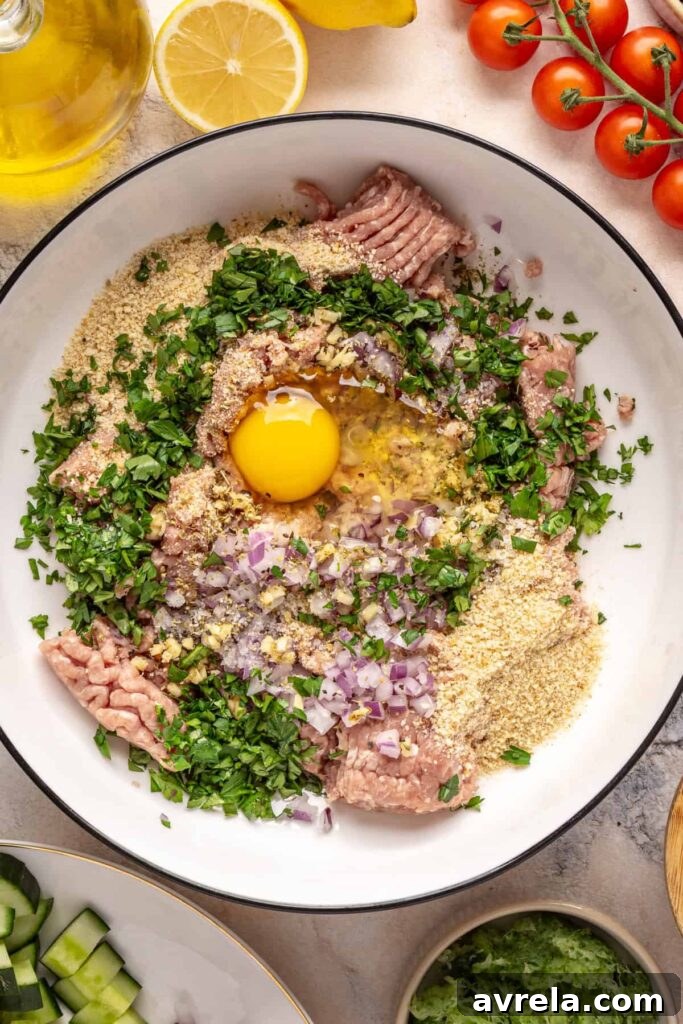 Ground turkey meatball mixture with herbs, garlic, and breadcrumbs in a bowl for Greek turkey meatballs.