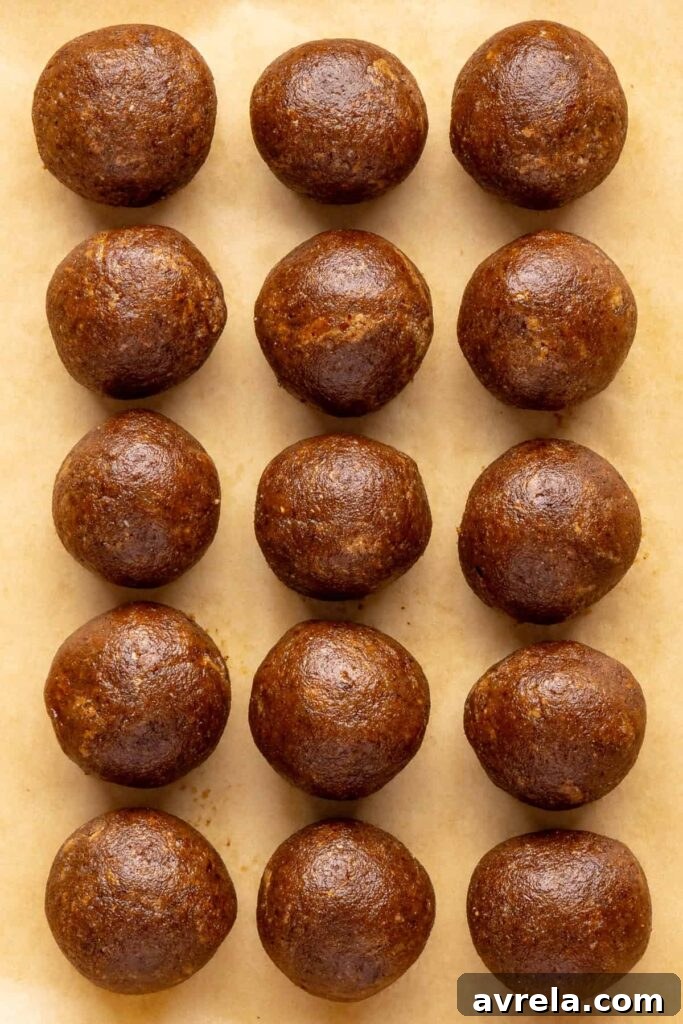 Chilled gingerbread protein balls on parchment paper, ready to drizzle with coconut butter