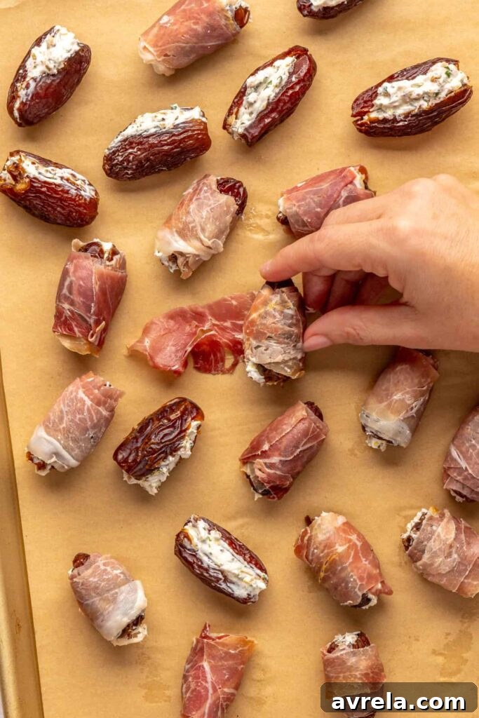 Wrapping stuffed dates with prosciutto slices on a baking sheet, ready to bake