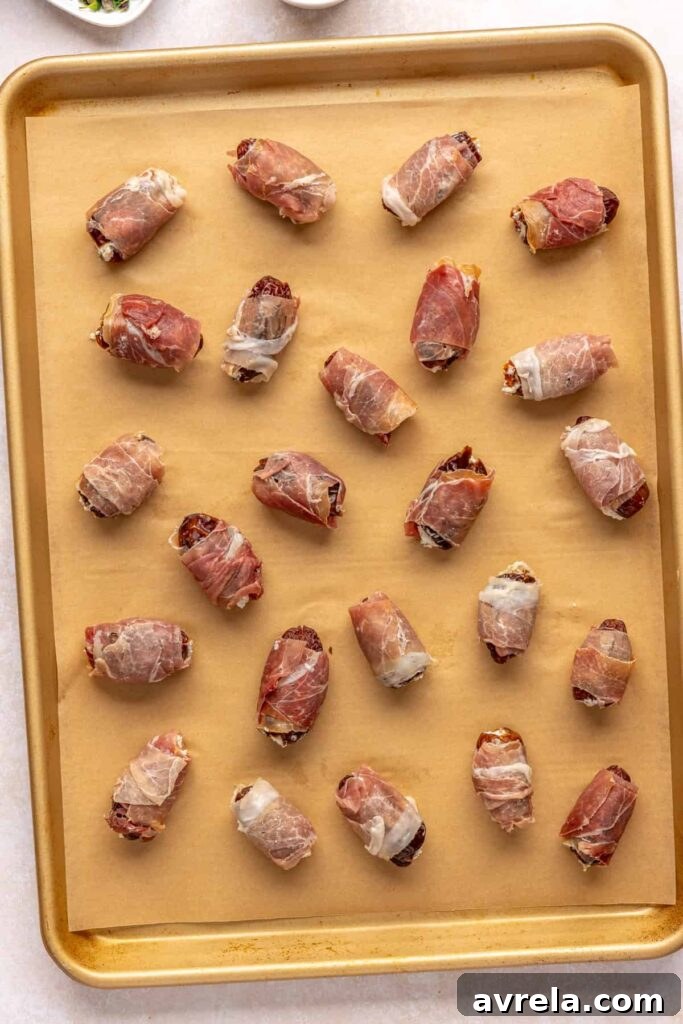 Prosciutto wrapped stuffed dates on baking sheet before going into the oven