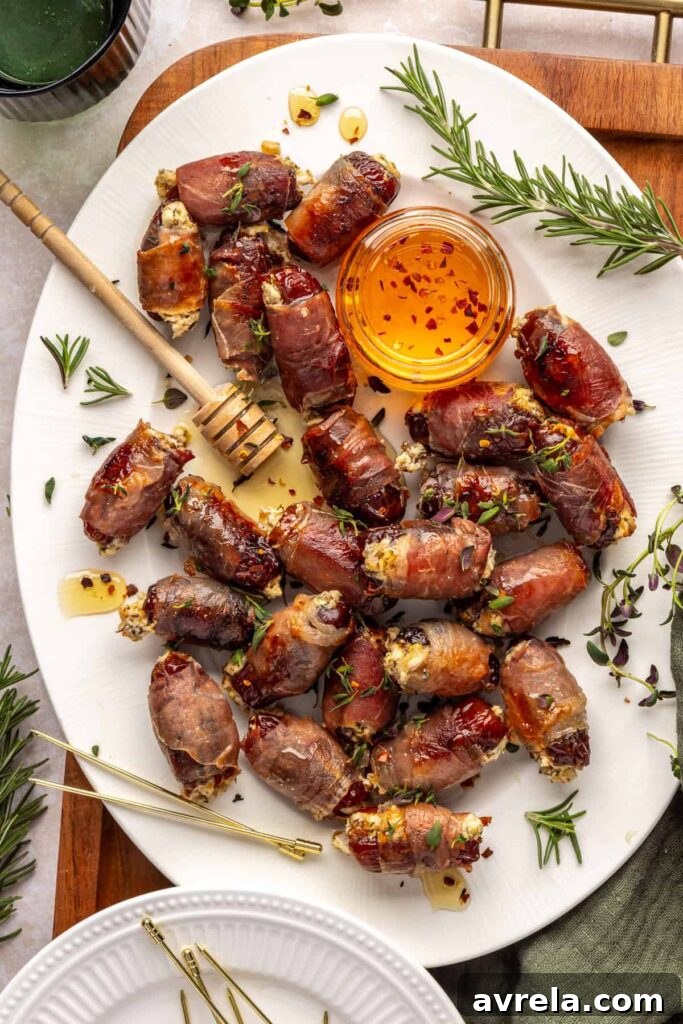Finished prosciutto wrapped stuffed dates on a serving tray, drizzled with hot honey and garnished with fresh thyme