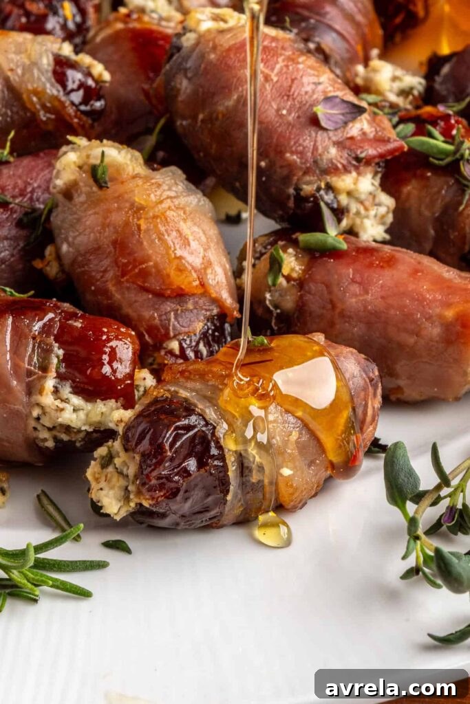 Profile view of hot honey being drizzled over baked stuffed dates with goat cheese and prosciutto