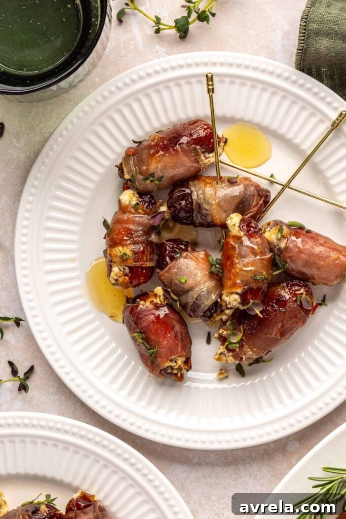 Individual prosciutto wrapped stuffed dates with goat cheese filling on plate