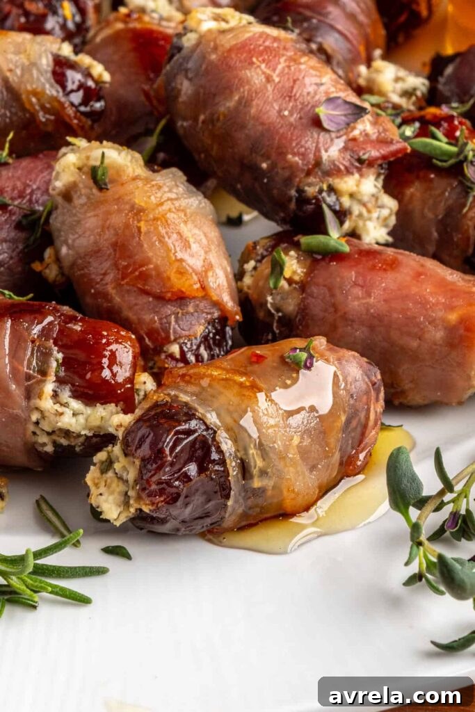 Profile view of baked stuffed date with goat cheese and prosciutto, drizzled with hot honey
