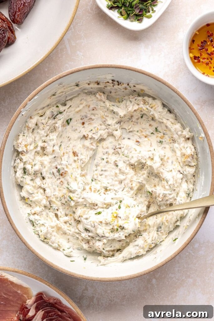 Herbed goat cheese filling fully combined in a bowl for easy prosciutto stuffed dates appetizer