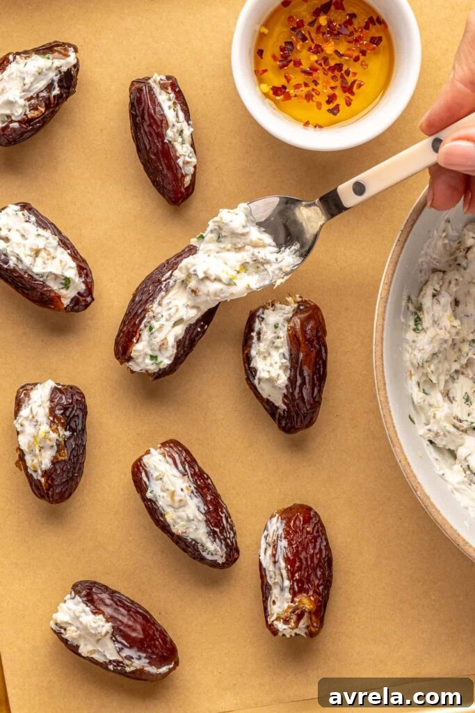 Spoon filling into pitted dates for easy prosciutto wrapped stuffed dates appetizer
