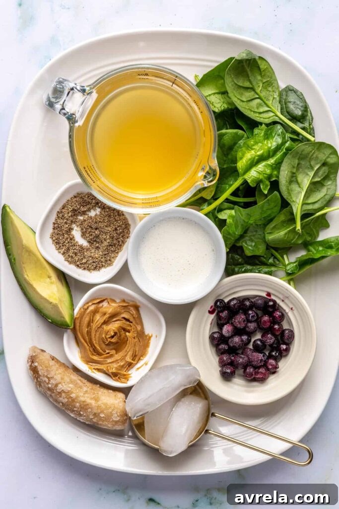Toddler Smoothie Recipes: Nutritious, Filling & Naturally Sweetened 6 Overhead view of ingredients for a toddler smoothie: banana, avocado, spinach, peanut butter, blueberries, and milk