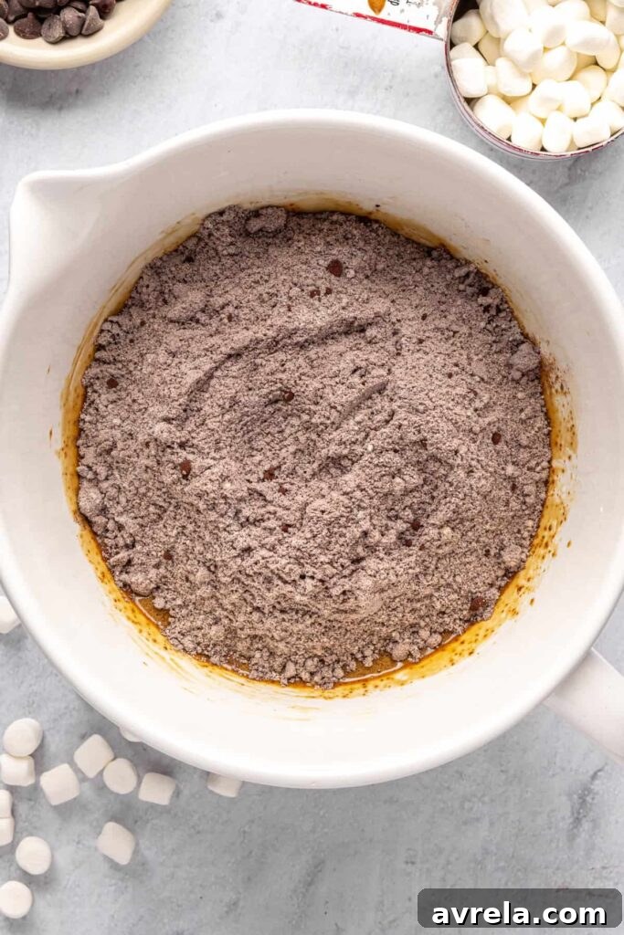 overhead shot of large mixing bowl with dry ingredients poured on top of the wet ingredients for hot cocoa cookies