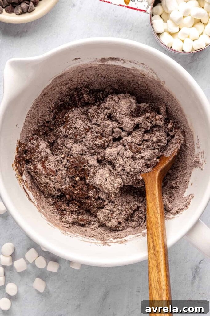 Combining wet and dry ingredients to form hot cocoa cookie dough