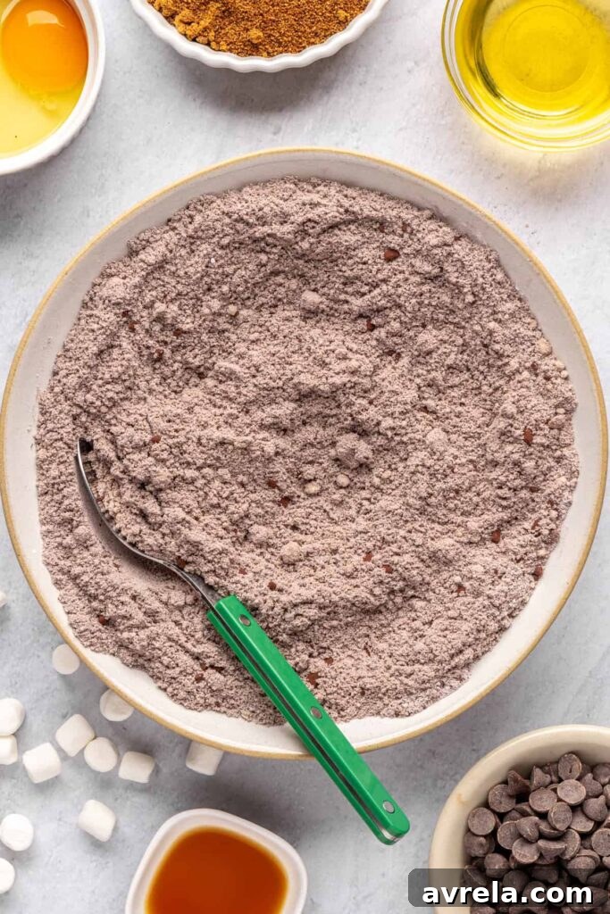 Whisking almond flour, arrowroot starch, cocoa powder, and espresso powder for hot cocoa cookie dough