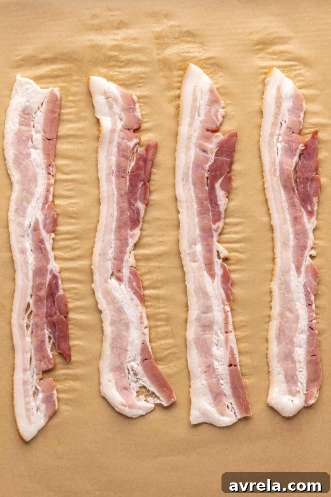 Applewood smoked bacon on parchment-lined baking sheet before baking