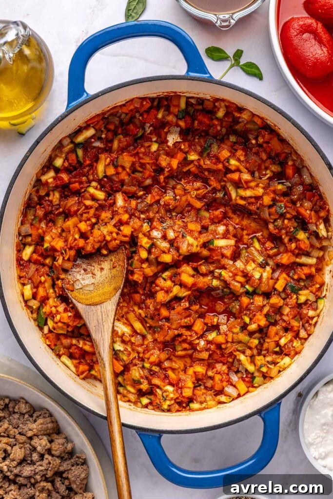 Overhead shot of tomato paste melting into vegetables for creamy vodka sauce