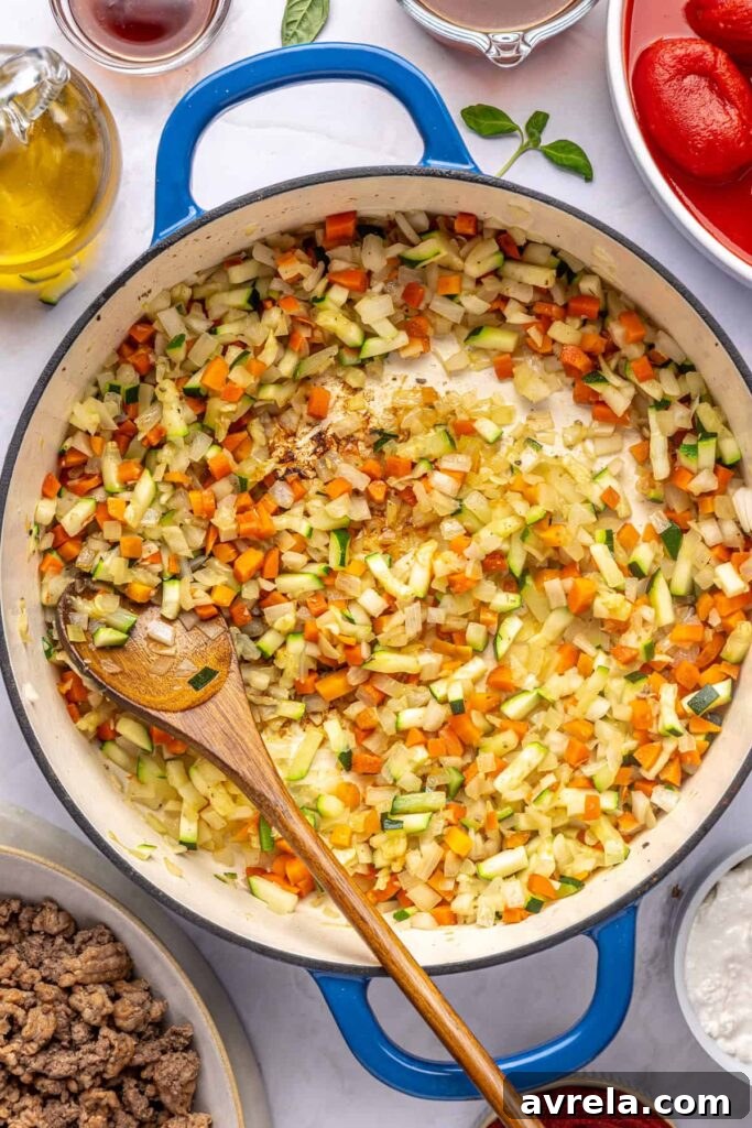 Vegetables cooking down in a Dutch oven for creamy vodka sauce with hidden veggies