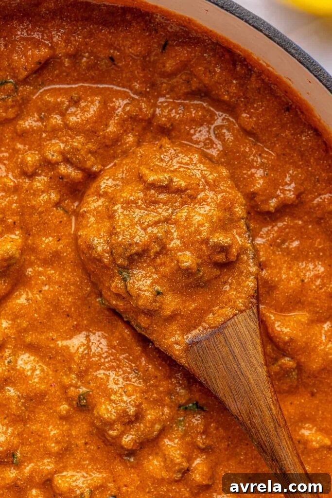 Thick, creamy vodka sauce with hidden veggies, photographed overhead in a Dutch oven with a wooden spoon