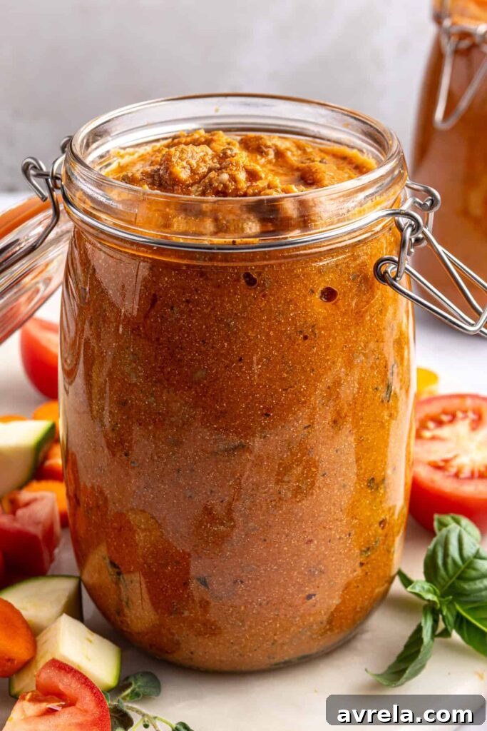 Creamy homemade vodka sauce with hidden veggies stored in a glass jar, styled overhead