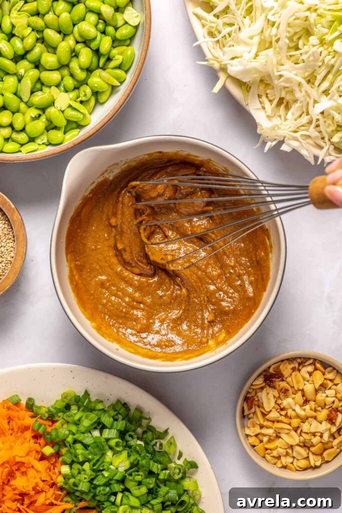 Whisking creamy peanut dressing until smooth for crunchy peanut cabbage salad