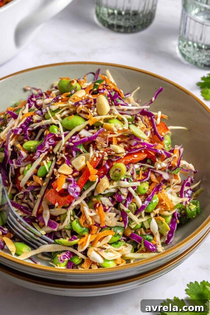 Close-up of individual bowl of peanut cabbage salad ready to eat with a fork