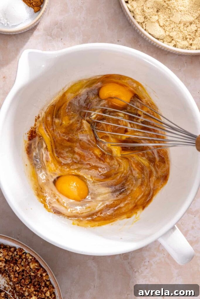 Whisking eggs, almond milk and coconut oil to make coffee cake muffin batter