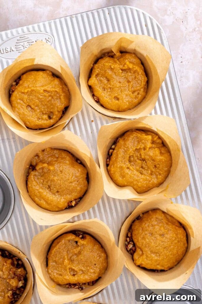 Filling muffin tin with coffee cake muffin batter