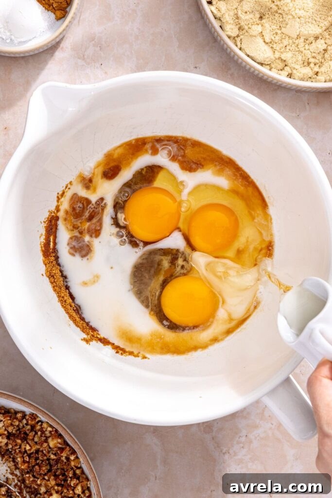 Mixing wet ingredients for gluten-free coffee cake muffins in a large bowl