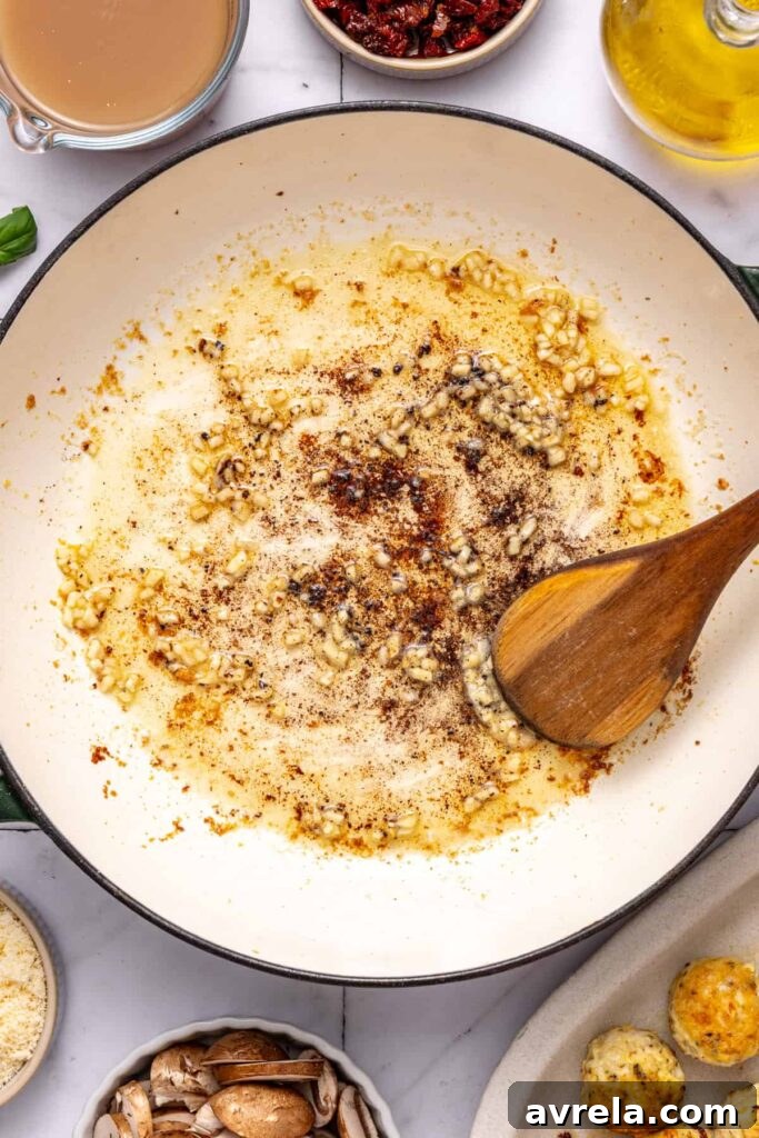 Cooking minced garlic in skillet for marry me chicken meatballs sauce