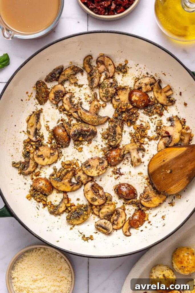 Blooming oregano and thyme in pan for creamy chicken meatball sauce