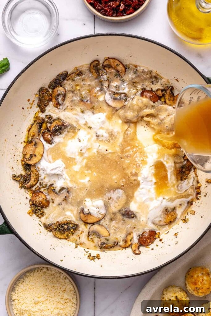 Pouring coconut cream and broth into skillet for marry me chicken meatballs