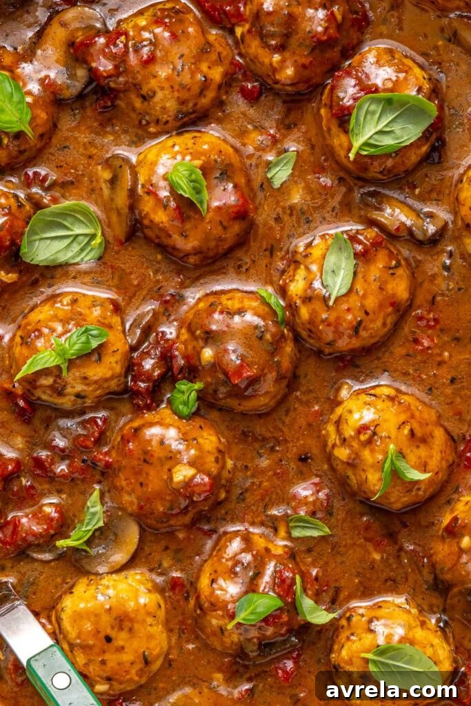 close-up of Marry me chicken meatballs with basil garnish in creamy sauce