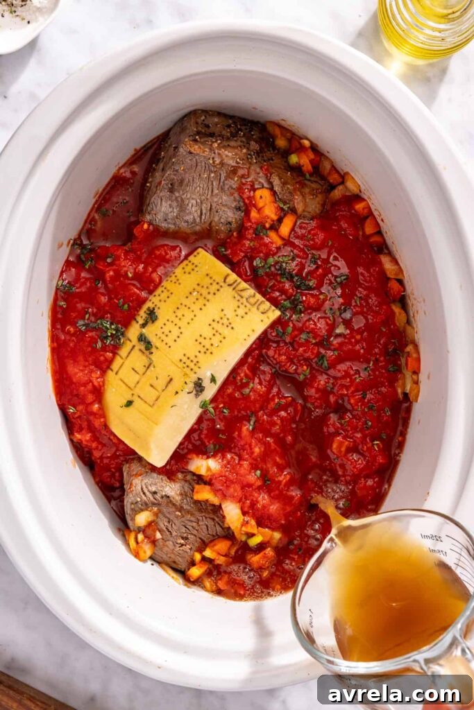 Assembling slow cooker short rib ragu with broth tomatoes and herbs
