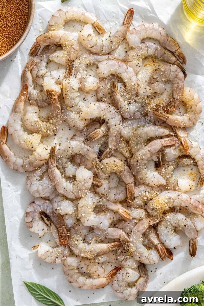 Raw shrimp seasoned with salt, garlic powder, and pepper for stir fry