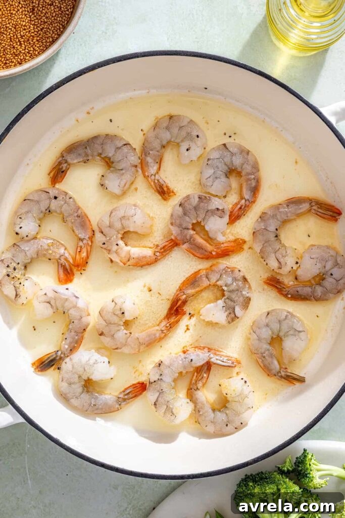 Shrimp cooking in skillet until pink and lightly golden for stir fry