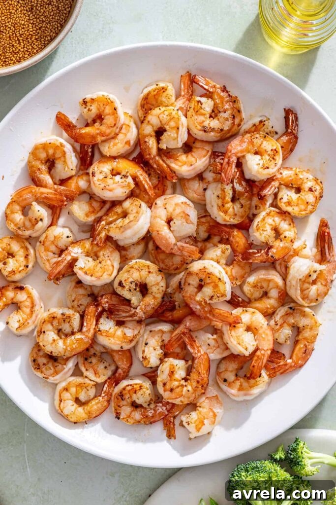 Cooked shrimp resting on plate before adding back to stir fry
