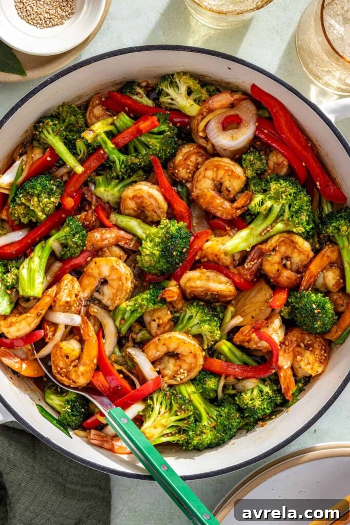 Shrimp stir fry finishing in pan as sauce thickens and coats ingredients