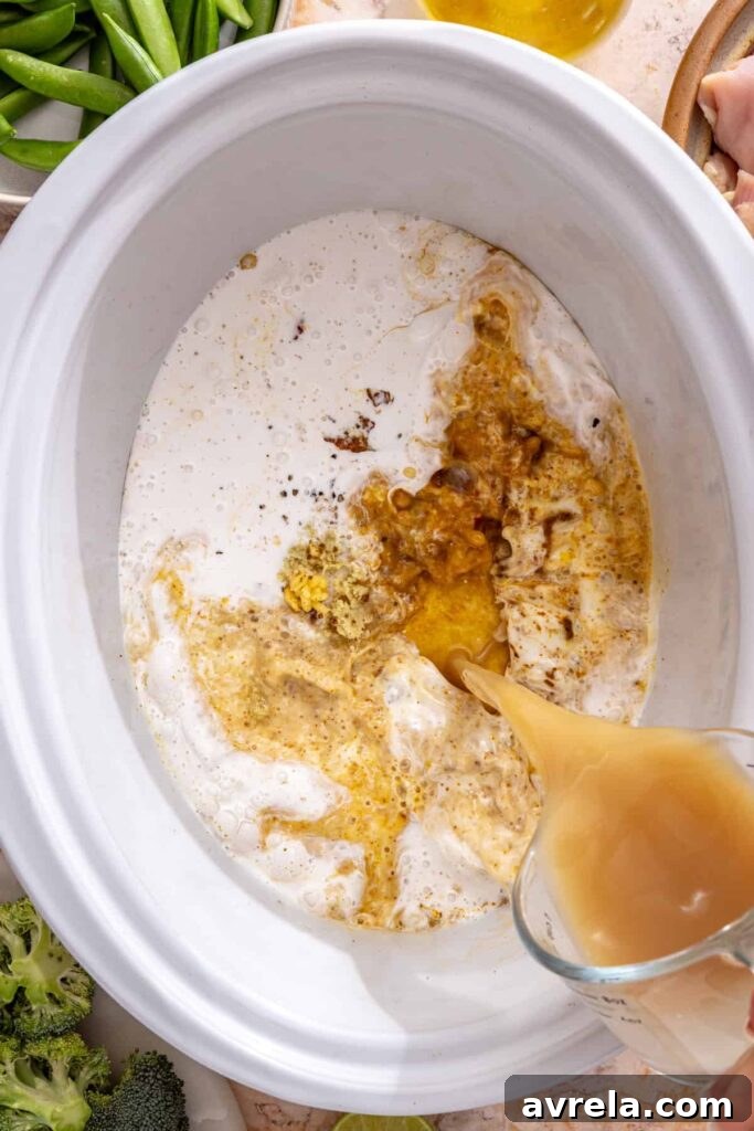 Slow Cooker Coconut Chicken Curry Recipe for Tender, Flavorful Meals 4 pouring bone broth and coconut milk into curry paste in slow cooker