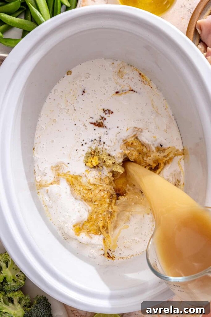 Slow Cooker Coconut Chicken Curry Recipe for Tender, Flavorful Meals 10 pouring bone broth and coconut milk into curry paste in slow cooker