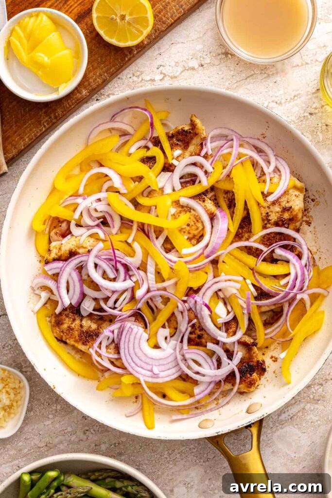 Wholesome Chicken Thigh Rice Bowls 10 Adding sliced red onions and bell peppers to the skillet with the seared chicken thighs