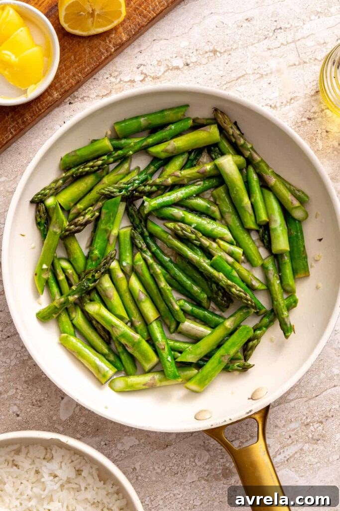Sautéing asparagus with garlic in skillet