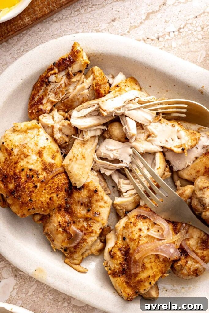 Shredding cooked chicken thighs with two forks