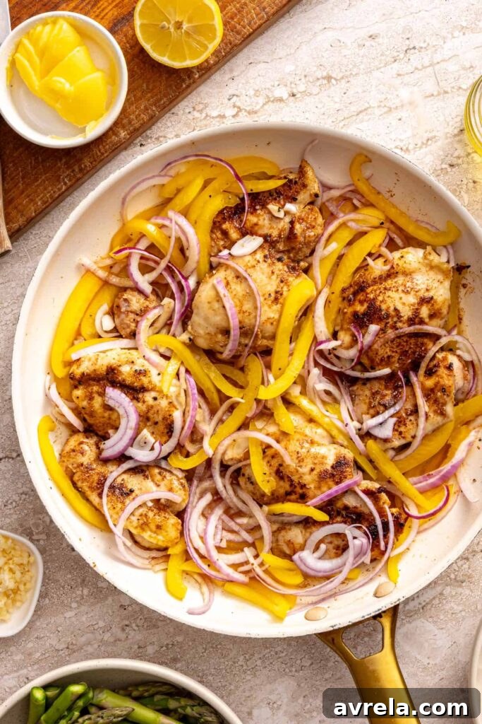 Wholesome Chicken Thigh Rice Bowls 4 Shredded chicken thighs cooking with colorful bell peppers and onions in a large skillet