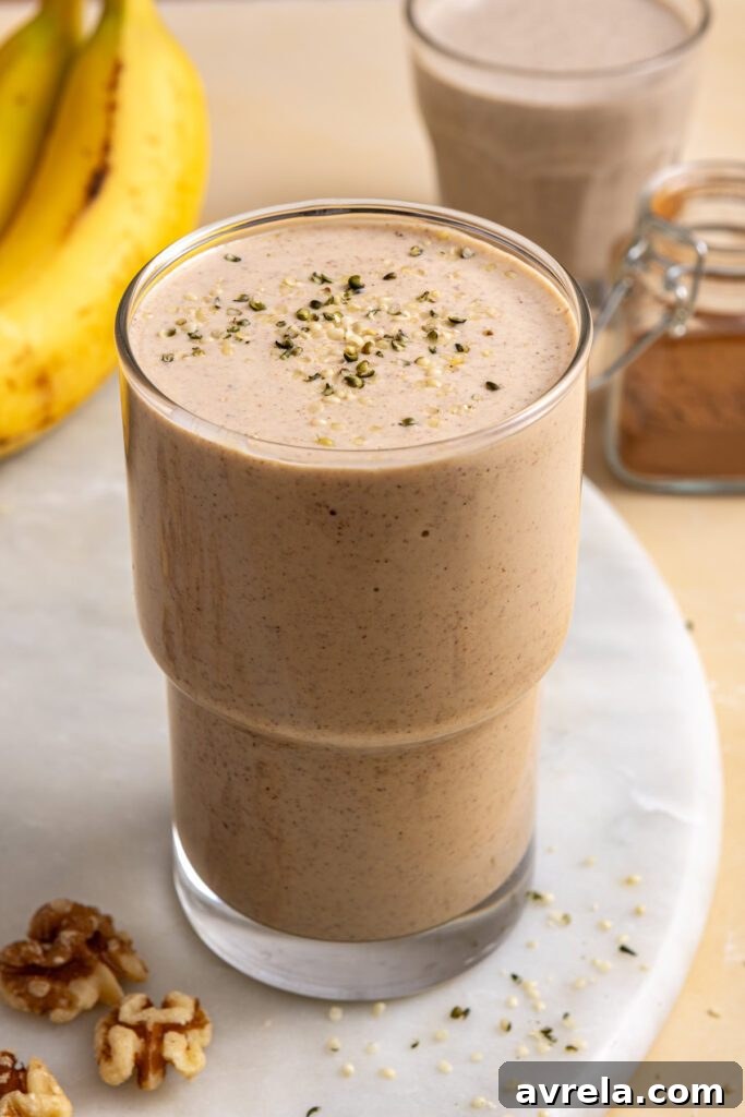 Banana nut smoothie in glass with smaller smoothie glass blurred in background