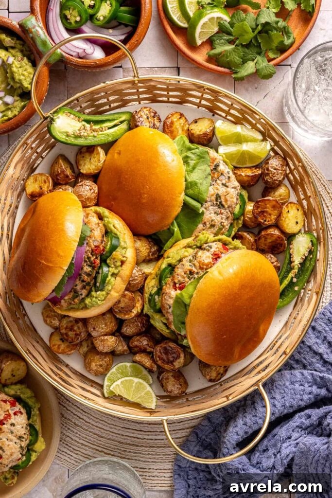 Jalapeño burgers plated with fresh toppings and sides on a summer tablescape