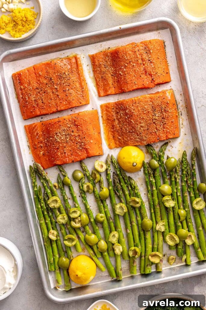 Seasoned salmon fillets and asparagus ready to bake