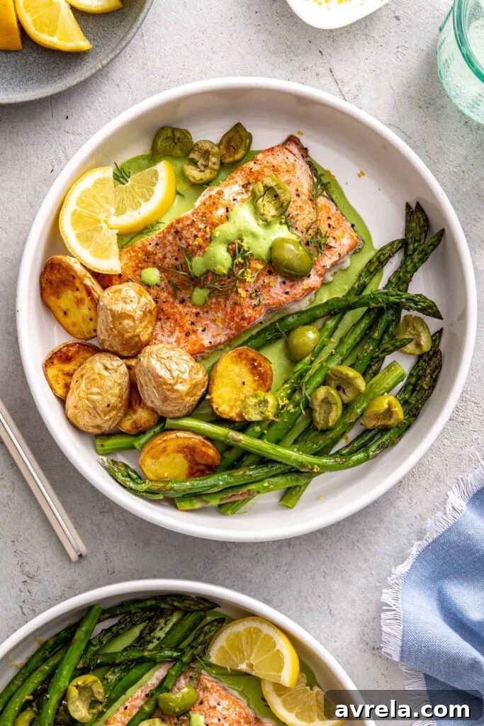 Healthy salmon and asparagus dinner bowl with lemon wedges and potatoes