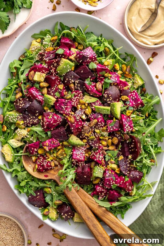 Overhead view of roasted beet salad served on a platter with a serving spoon