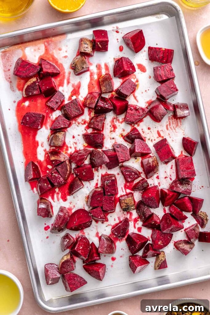 Seasoned beets on a parchment-lined baking sheet before roasting