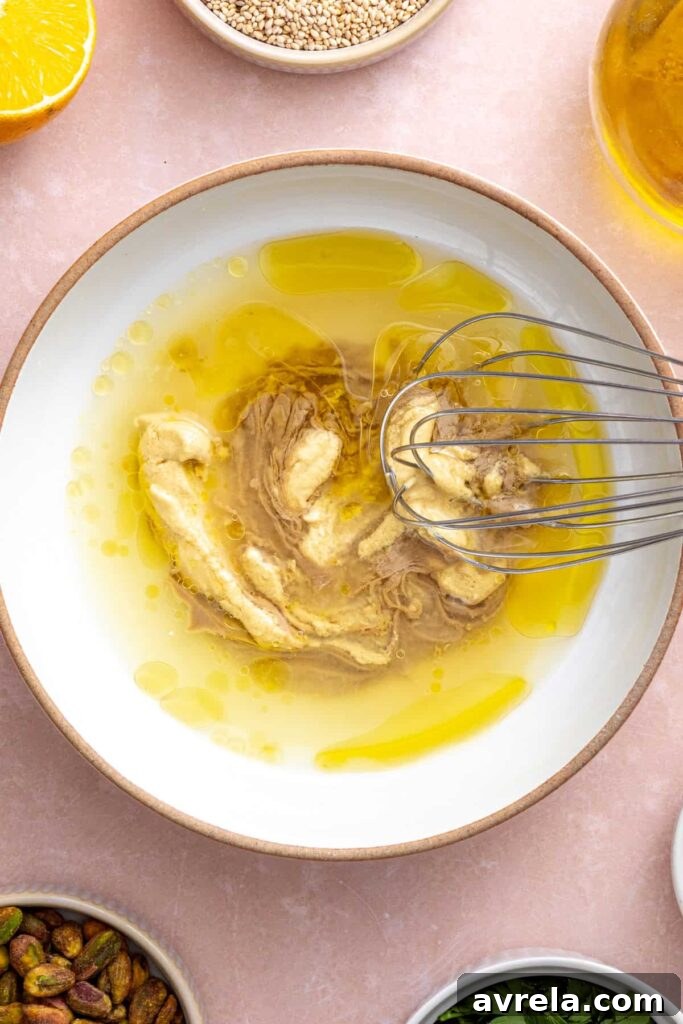 Tahini dressing being whisked in a large bowl