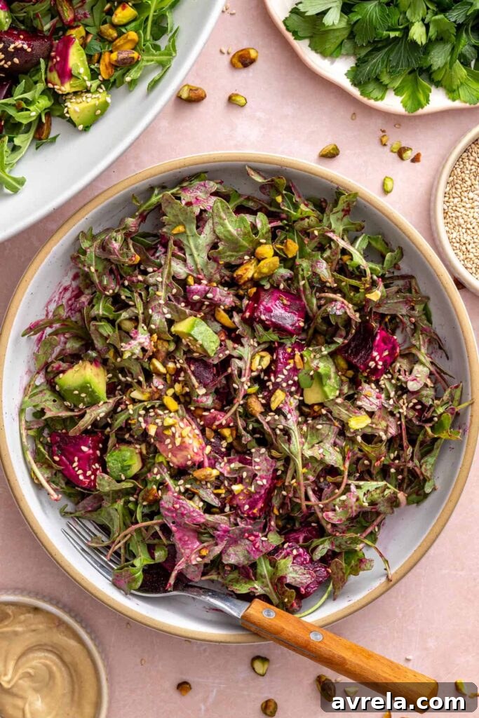 Tossed roasted beet salad served in a bowl with a fork