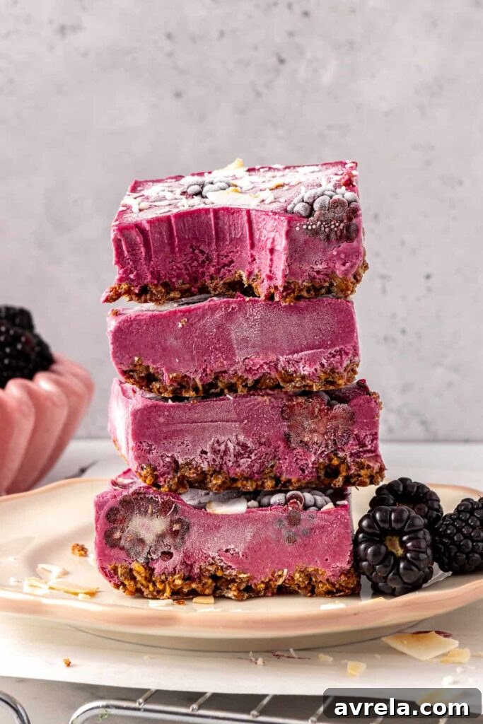 Blackberry cobbler bars stacked with bite showing creamy filling