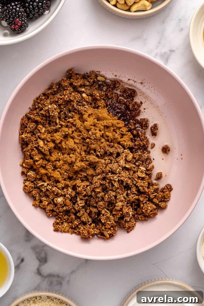 Granola mixed with melted coconut oil and cinnamon for blackberry cobbler bars crust