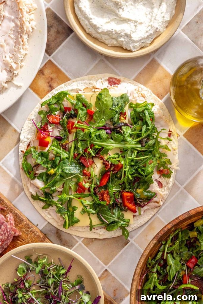 Greens mixture added over turkey and cheese on tortilla